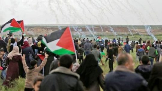 Warga Palestina berunjuk rasa di perbatasan Jalur Gaza berlari menghindari tembakan gas air mata yang diluncurkan melalui drone milik militer Israel, Jumat (30/3/2018).