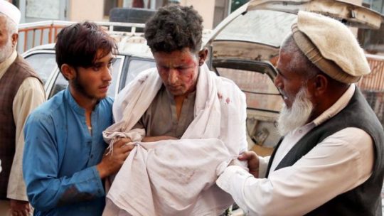 Seorang remaja mendapat pertolongan pertama setelah ledakan berlangsung di sebuah masjid di Provinsi Nangarhar, Afghanistan. (Foto: EPA via BBC).