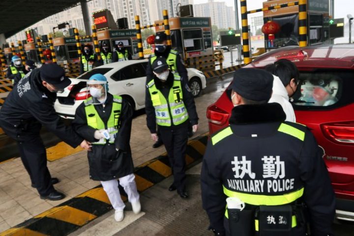 Petugas polisi melakukan pemeriksaan di stasiun tol di Xianning, sebuah kota yang berbatasan dengan Kota Wuhan di provinsi Hubei, Cina, pada 24 Januari 2020. FOTO: REUTERS via The Straits Times