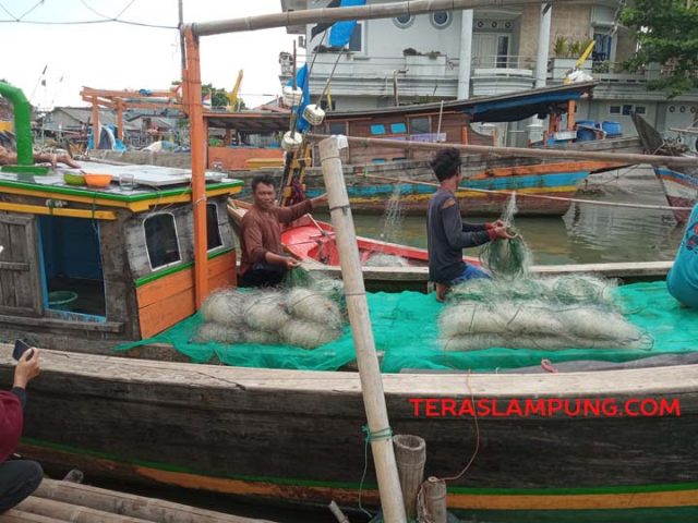 Kadim dan anaknya mengecek jaring di atas kapal miliknya, Selasa (19/10/2021). Foto: Teraslampung.com/Mas Alina