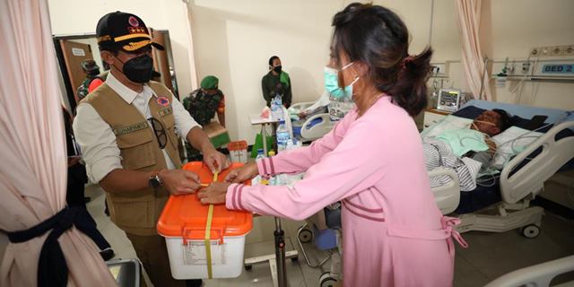 Kepala BNPB Letjen TNI Suharyanto (kiri) menyerahkan dukungan logistik kepada pasien terdampak awan panas guguran Gunung Semeru yang dirawat di RSUD Pasirian, Kabupaten Lumajang, Jawa Timur, Senin (6/12/2021). (Komunikasi Kebencanaan BNPB/Danung Arifin)