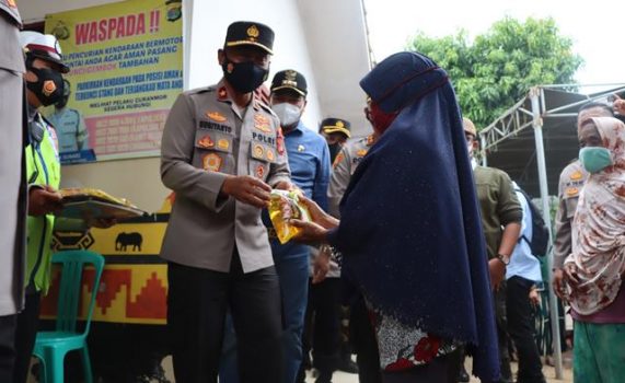 Wakapolda Lampung Brigjen Subiyanto menyerahkan minyak goreng kepada warga Kampung Bulusari, Lampung Tengah, yang baru saja divaksinasi, Jumat (25/2/2022).