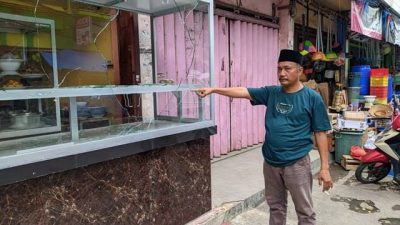Pemilik RM Singgalang Indah di Pasar Bambu Kuning Bandarlampung, Pendi, menunjukkan kaca etalase miliknya yang dipecahkan orang tidak dikenal.