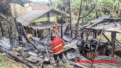 Petugas pemadam dari DPKP Kota Bandarlampung sedang mematikan sisa-sisa api kebakaran di gudang mebel, Jl. Agus Salim, Bandarlampung, Jumat sore (21/10/2022).