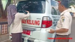 Petugas Bapenda Provinsi Lampung menempelkan stiker bagi kendaraan yang menunggak pajak.