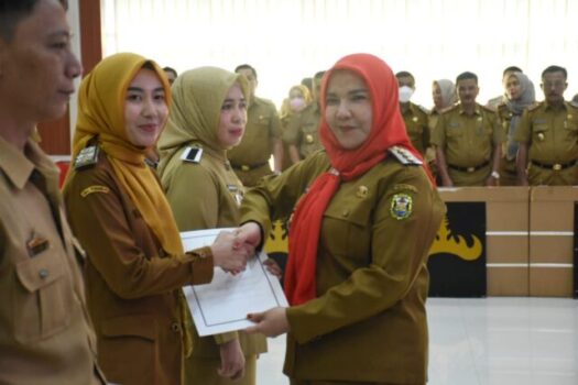 Walikota Eva Dwiana menyerahkan secara simbolis petikan keputusan kenaikan pangkat kepada salah seorang PNS.